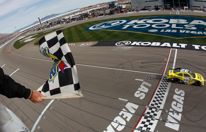 Mark Martin takes the checkered flag in the Nationwide Series race at Las Vegas. The veteran driver grabbed the lead when Brad Keselowski had a flat tire and hit the wall on the final lap.