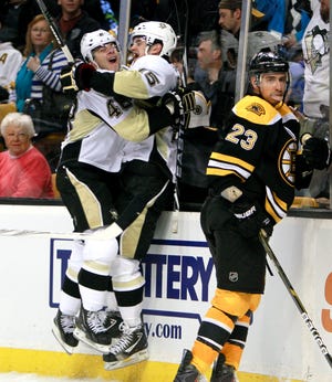 The Penguins' Dustin Jeffrey, center, celebrates his game-winning goal with Tyler Kennedy as Chris Kelly looks away during the Bruins' 3-2, overtime loss on Saturday night.