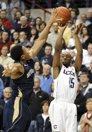Connecticut's Kemba Walker, right, shoots past Notre Dame's Tyrone Nash during the first half of an NCAA college basketball game in Storrs, Conn., on Saturday, March. 5, 2011.