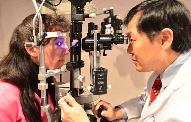 Dr. Sungjun John Hwang at the Eye Care Center in Canandaigua performs a slit lamp eye exam on Jennifer LaCrosse of Farmington on Tuesday March 1, 2011.