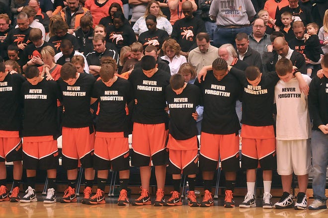 Fennville's basketball team members bow their heads for a moment of silence prior to tipoff against Lawrence Monday night. It is Fennville's first game since student athlete Wes Leonard died after playing in a basketball game March 3.