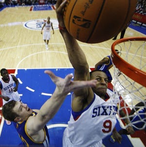 The 76ers' Andre Iguodala goes up for a dunk despite the efforts of the Warriors' David Lee during Friday's overtime win at the Wells Fargo Center. (AP Photo/Matt Slocum)
