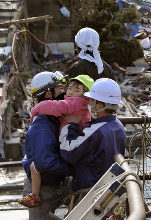 A girl who was left inside a building is rescued in Kesennuma, Miyagi, northern Japan Saturday.