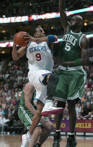 Boston Celtics' Kevin Garnett (5) defend as Philadelphia 76ers' Andre Iquodala (9) scores in the second half of an NBA basketball basketball game Friday, March 11, 2011, in Philadelphia. The 76ers won 89-86. (AP Photo/H. Rumph Jr)