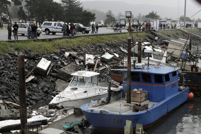 Locals look at the damage at the boat basin Saturday, March 12, 2011, in Crescent City, Calif., after Friday's tsunami in Northern California. (AP Photo/The Times-Standard, Josh Jackson)