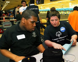 Volunteer Christian Hobson (right), an eighth-grader at the Lumberton Middle School, talks with bowler Lee Benbow of Willingboro about his score.