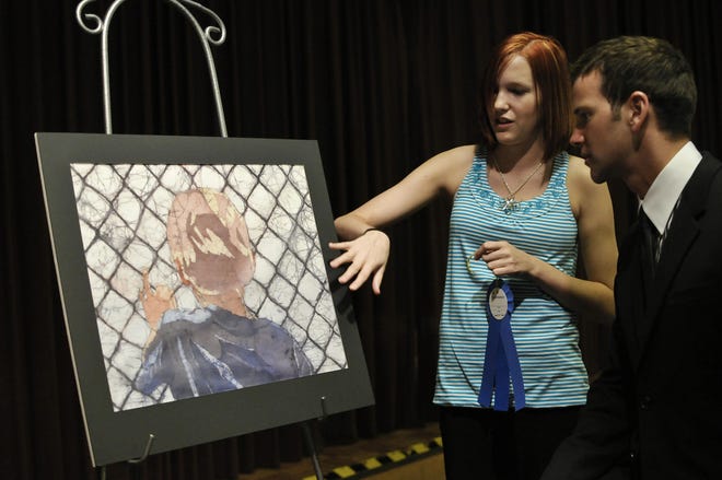 Tiffanie Bell, 17, a junior at Havana High School, explains the process she used to create the winning entry to the 27th annual Congressional Art Competition to U.S. Rep. Aaron Schock on Saturday. Bell's bastik will hang in the U.S. Capitol for one year beginning in June.