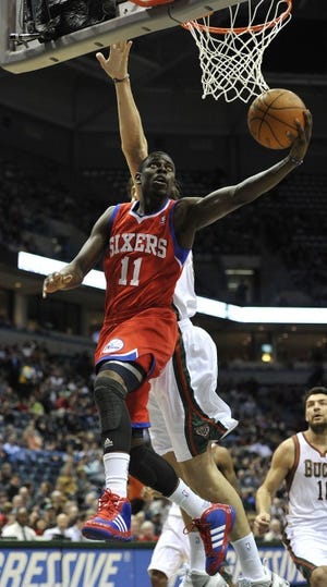 The 76ers' Jrue Holiday drives to the basket around the Bucks' Andrew Bogut during the first half of Milwaukee's 102-74 win Saturday. (AP Photo/Jim Prisching)