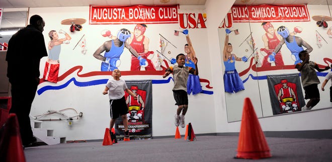 Ray Whitfield works with Angel Torres, 9, and Brad Miller, 10, on agility training at Augusta Boxing Club. The city began paying the utilities and salaries for the club when it secured the trials for the 1996 Olympic Games, but says it can no longer afford it.