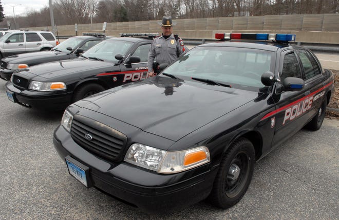 Montville Police Sgt. Earnie Greenwood stands with three of the Ford Crown Victoria's used by the Montville police department. The cruiser in the front is a 2000 Crown Victoria that has over 98,500 miles.