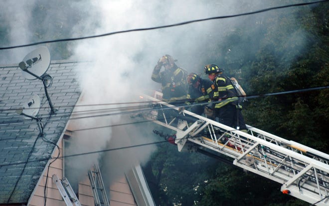 Firefighters pour water on a fire on Mechanic Street in North Easton in 2009. The town may be forced to close one of three fire stations because of budget difficulties.