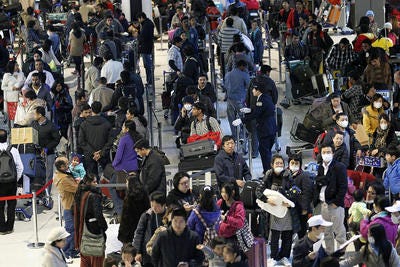 Passengers crowd a check-in area at Narita Airport, east of Tokyo, Friday. The airport was crowded with evacuees and regular passengers Friday following advisories from foreign governments recommending citizens leave the country, as the crisis at Japan's Fukushima Dai-ichi nuclear plant in the northeast deepened.