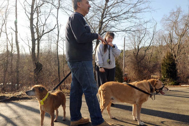 Mr. Blancato talks with foster mother Michelle L. Bennett. At left is rescued dog Trevor; dog Mickey is at the right.