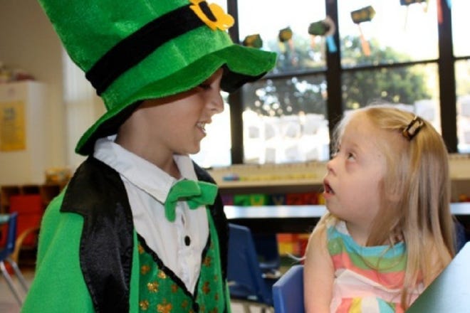 Right: Emma Richter is spellbound by the sight of a leprechaun this week at Our Lady Star of the Sea Catholic Church's Little Stars Preschool in Ponte Vedra Beach. The leprechaun is actually Palmer Catholic Academy student Scott Dishmon, who visited the pre-school in the spirit of St. Patrick's Day.