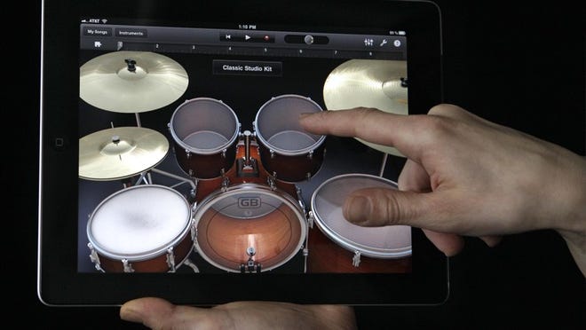 The iPad 2 — shown using the Garage Band app — includes extras such as AirPlay and AirPrint for wireless streaming and printing, as well as video mirroring.