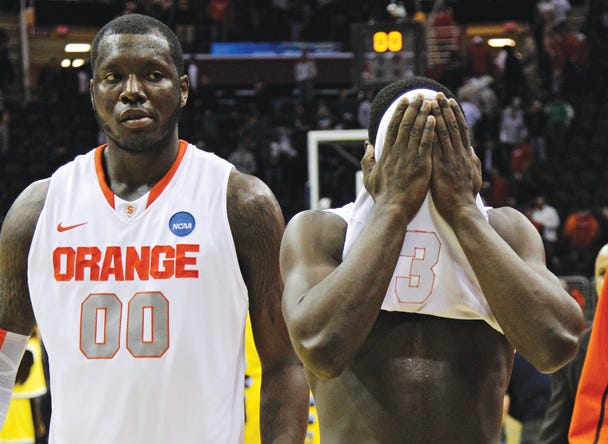 Syracuse's Rick Jackson (00) and Dion Waiters walk off the court after a 66-62 loss to Marquette in an East regional NCAA college basketball tournament third-round game, Sunday, March 20, 2011, in Cleveland. (AP Photo/Amy Sancetta)