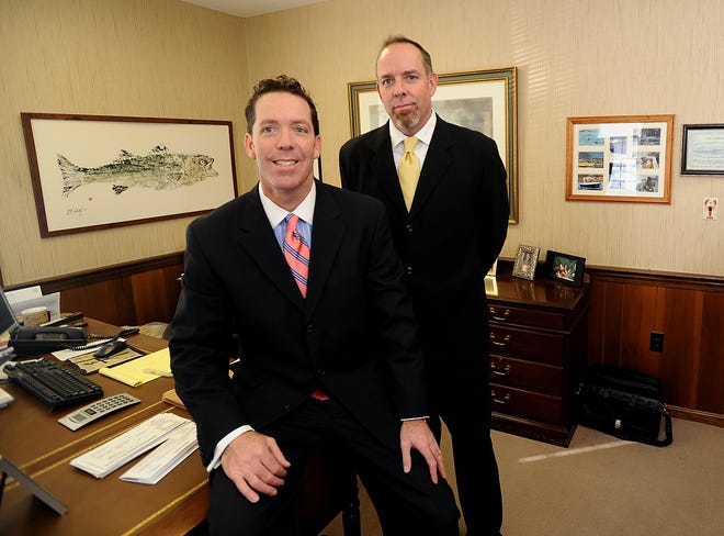 John Doherty, right, president of Lehrer & Madden Insurance Inc., and his brother, Michael Doherty, the company's vice president, are seen in the firm's Natick headquarters.
