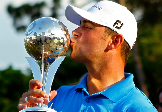 Gary Woodland kisses the trophy after winning the Transitions Championship on Sunday. The Associated Press