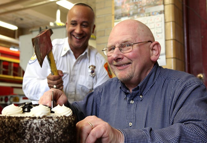 From left, Rockland Firefighter Craig Erickson gives retiring call firefighter Al McPhee a fireman’s axe to cut the cake the old fashioned way during the latter’s last day on the job. McPhee retired last week after more than 30 years with the Rockland department.