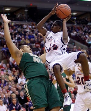 Bishop Hartley's Jordan Fair, right, shoots over Saint Vincent Saint Mary's D.J. Williams during the second half of a Division II Ohio high school state semifinal basketball game.