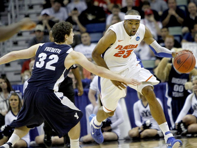 Florida Gators forward Alex Tyus (23) drives past BYU Cougars guard Jimmer Fredette (32) after getting a defensive rebound in the second half of their NCAA tournament regional semifinal game at the New Orleans Arena on Thursday.