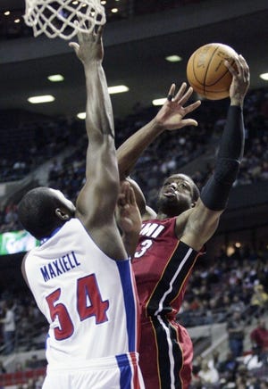 The Miami Heat's Dwyane Wade goes to the basket against the Detroit Pistons' Jason Maxiell during Wednesday's game in Auburn Hills, Mich. (AP Photo/Duane Burleson)