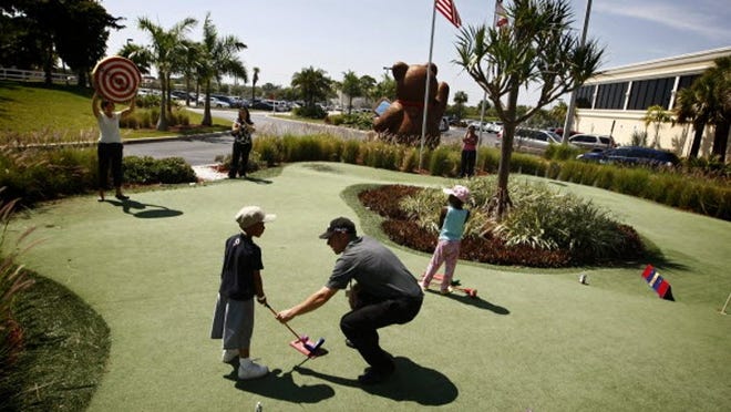 Patient Damonte Knight, 5, gets instructions from pro Ryan Alvino during golf lessons with The Child Life Program based at The Children's Hospital at St. Mary's Medical Center Wednesday, March 23, 2011.
