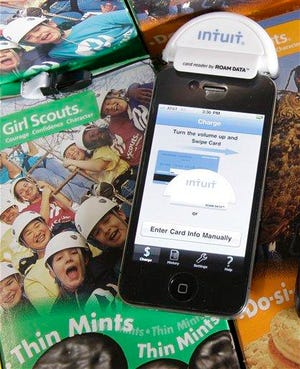 This March 21, 2011 photo shows a GoPayment machine attached to a smartphone used by the members of Girl Scout Troop 70024 as a way to accept credit card payments for cookie sales at Parkside Elementary School in Solon, Ohio. Girl Scout leaders hope that allowing customers to pay with plastic will drive up cookie sales.
