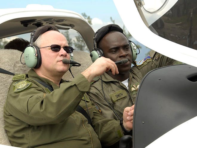 In this Dec. 7, 2006 file photo, Maj. Gen. Charles Bouchard, left, sits in the cockpit of a DA40 Diamond Star as he listens to Lt. Chevon Smith, in Montego Bay, Jamaica. Canadian Defense Minister Peter MacKay said Friday, March 25, 2011 that Lt.-Gen. Bouchard has been designated to lead the alliance's military campaign in Libya. (AP Photo/The Canadian Press, M.Cpl. France Huard) NO SALES