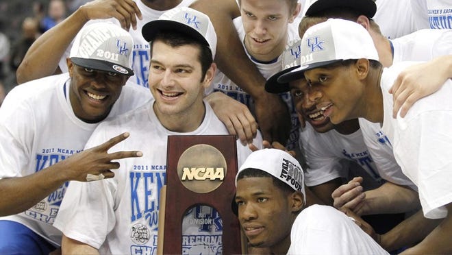 Kentucky's Josh Harrellson (second from left, in front) joins teammates in holding the regional trophy Sunday. 'We got Kentucky back (to the Final Four). A lot of people doubted us,' Harrellson said.
