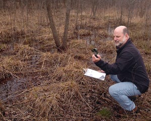 Steve Mattan, a volunteer for the Calling Amphibians Monitoring Project, checks his pocket weather tracker along a marshy area in the Rancocas Nature Center in Westampton last week.