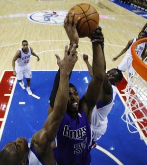 The Kings' Jason Thompson goes up for a dunk between the Sixers' Jodie Meeks (left) and Jrue Holiday during Sacramento's 114-111 overtime victory Sunday at the Wells Fargo Center. Thompson finished with 15 points and 11 rebounds. (AP Photo/Matt Slocum)