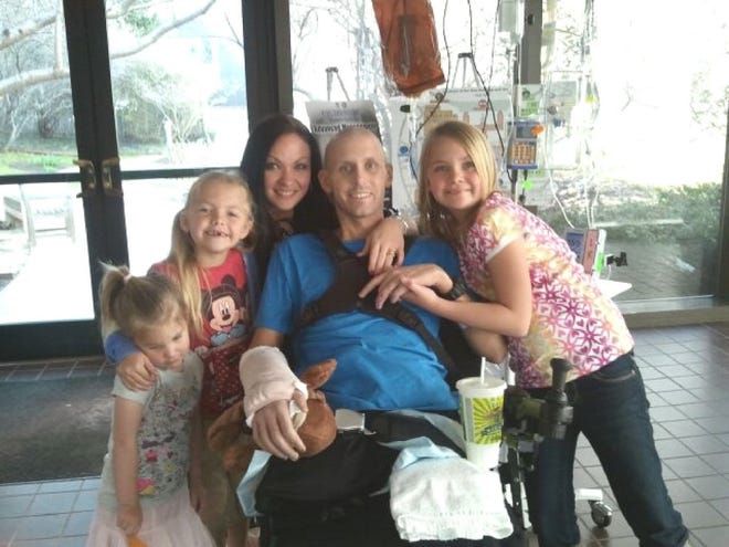U.S. Marine Corps Gunnery Sgt. John Hayes, here with his wife, Janel, and their three daughters, has undergone 51 surgeries after stepping on an IED in Afghanistan.