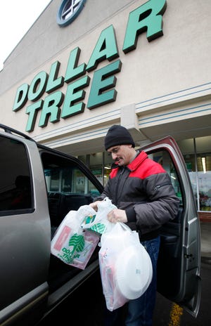 In this March 16, 2011 photo, Larry Buckley leaves a Dollar Tree store in Batavia, N.Y. Consumer spending rises at fastest pace since October, led by purchases of autos and gasoline. (AP)