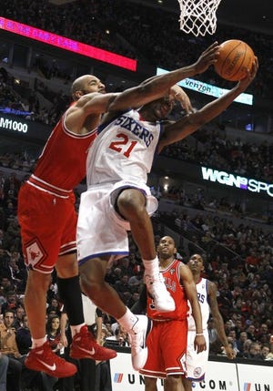 The Bulls' Carlos Boozer fouls the 76ers' Thaddeus Young during the Sixers' 97-85 win Monday in Chicago. Young contributed a team-high 21 points. (AP Photo/Charlie Arbogast)