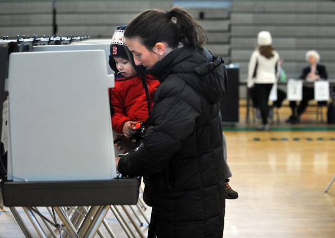 Mary Krattenmaker fills out her ballot with her son Joseph, 2, at Hopkinton Middle School on Monday.