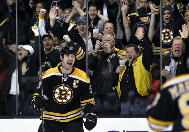 Fans cheer as Bruins defenseman Zdeno Chara turns to his teammates after scoring a goal against the Blackhawks during the second period of last night's win.