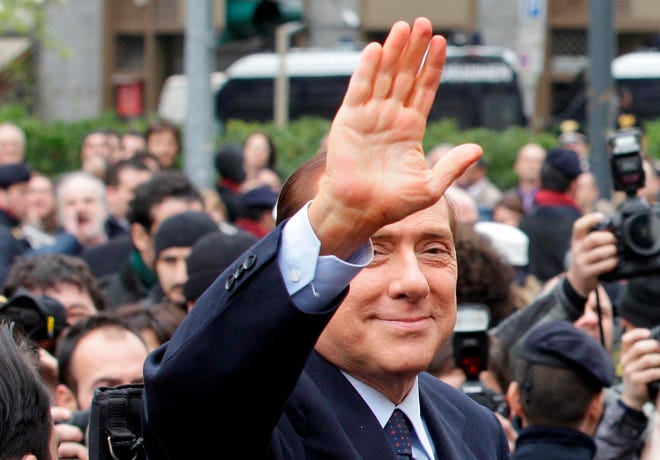 Italian Premier Silvio Berlusconi gestures as he leaves the tribunal in Milan, Italy, on Monday. Silvio Berlusconi made a rare appearance Monday at a court hearing in Milan for a tax fraud case that he dismissed as groundless and ridiculous. Berlusconi waved to a crowd of reporters and supporters from inside a black sedan as he entered the courthouse for the closed-door hearing. Prosecutors allege fraud in the sale of film rights by his Mediaset company. The Italian leader has a history of legal woes but has rarely showed up in court. He has always denied wrongdoing and denounced what he says are left-leaning magistrates intent on hurting him politically. (The Associated Press)