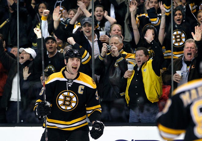 Fans cheer as Boston defenseman Zdeno Chara turns to his teammates after scoring a goal against the Chicago Blackhawks during the second period of last night's game.