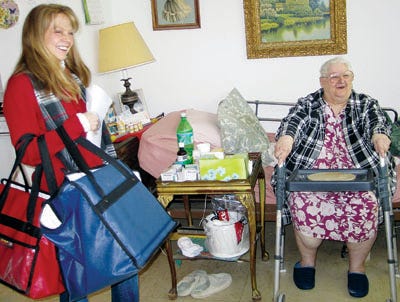 Photo by Lyndsay Cayetana Bouchal/New Jersey Herald 
Newton Mayor Kristi Becker, left, delivers a meatloaf dish Wednesday to the gleeful Gloria Bell, right, in her Newton apartment as part of the Sussex County chapter of Meals on Wheels’ March for Meals Campaign.