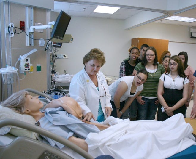Nursing instructor Jane Bowditch (left) demonstrates a Human Patient Simulator for Middleburg and Ridgeview high school students during a recent open house at the Orange Park campus of St. Johns River State College. The open house provided information about the admissions process, scholarships and SJRSC programs.