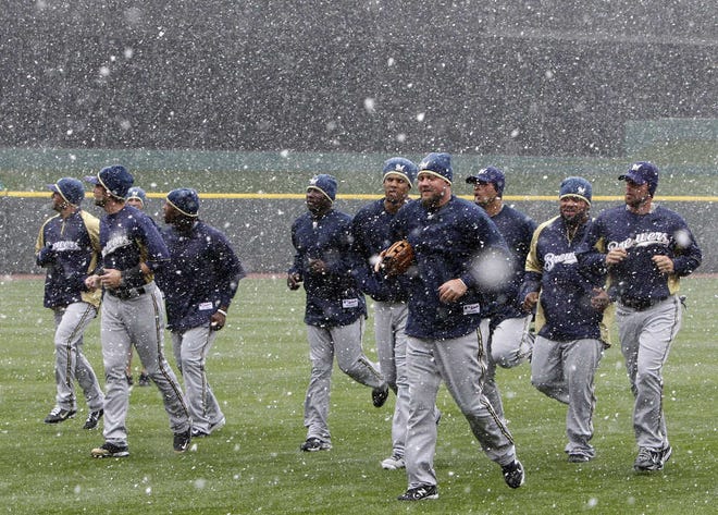 The Brewers jog in the snow yesterday at Great American Ball Park in preparation for today’s opener in Cincinnati.