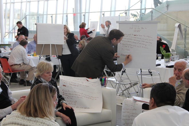 Future Search participants write down ideas earlier this week during the three-day conference at Haworth Inc.’s headquarters in Holland.