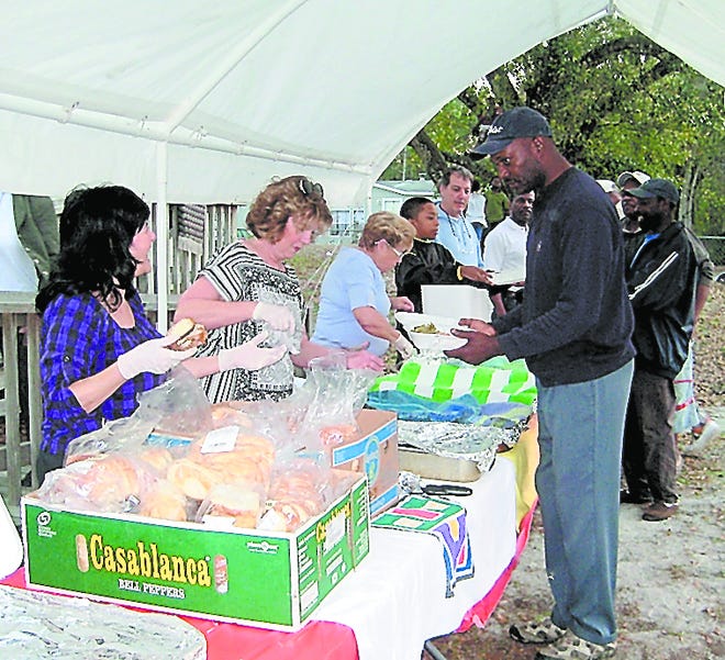 Volunteers distribute hot meals and food and clothing bags to those attending the monthly SEA gatherings in Armstrong. Contributed photo
