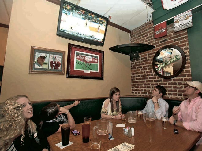 From left, University of Alabama students Morgan Green, Jody Watson, Julie Muhlendorf, Courtney Martin, Justin Woljevach and Aaron Dale watch the Tide take on Wichita State in the National Invitation Tournament championship game at Wilhagan's Sports Grille on Thursday.