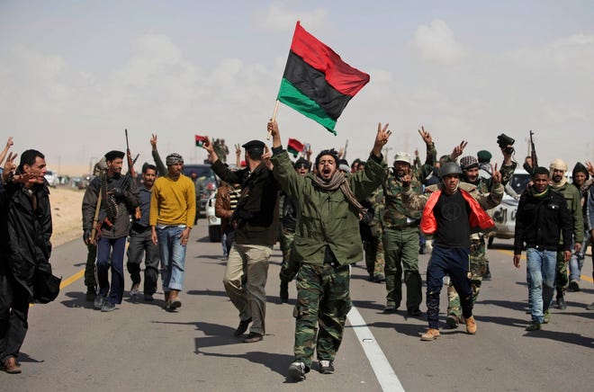 Rebels shout slogans Friday at a front-line position near Port Brega, Libya, 
as they hear about airstrikes launched against forces loyal to Moammar 
Gadhafi.