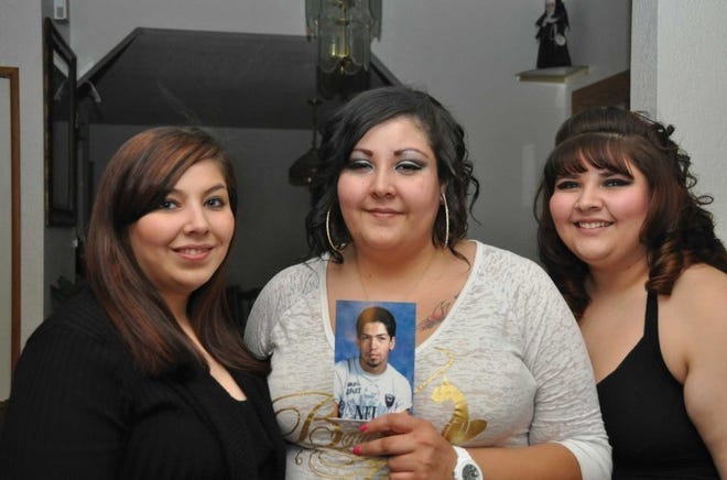 Edwina Romo shows a picture of her brother, Chris Romo. She is flanked by her sisters, Beverly (left) and Hillery.