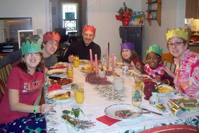 This Dec. 25, 2010 picture provided by the Franklin family shows from left, Olivia, 11; Elliot, 16; Tim Franklin; Emma, 7; Gedeleine, 3; and Annette Franklin in their dining room, eating their traditional Christmas morning breakfast. Gedeleine, who is HIV positive, was adopted from Haiti following the earthquake there in January 2010. While most adoptions present challenges, there's a distinctive set facing parents who decide to adopt children living with HIV. A twice-daily medication regimen, lingering prejudice and fear, uncertainty about the child's longevity and marriage prospects. Yet the number of U.S. parents undertaking HIV adoptions, or seriously considering them, is surging. Most involve orphans from foreign countries where they faced stigma, neglect and the risk of early death. (AP Photo)