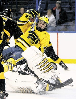 Michigan forward Ben Winnett , top, collides with Colorado College goaltender Joe Howe during the second period of the West regional championship NCAA college hockey game, Saturday, March 26, 2011, in St. Louis, Mo.
