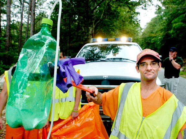 Etowah County inmate Michael Clayton of Walnut Grove holds up a “shake and bake” portable meth lab he found July 17, 2009, while picking up litter along Egypt Mountain Road.